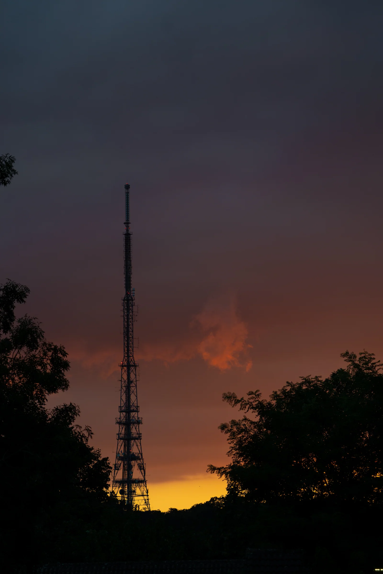 Broadcast tower against an amber evening sky